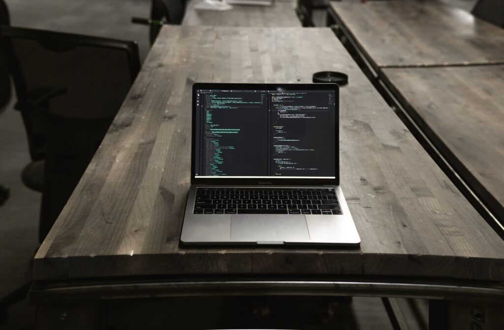 Ein Laptop mit Programmiercode auf einem Schreibtisch